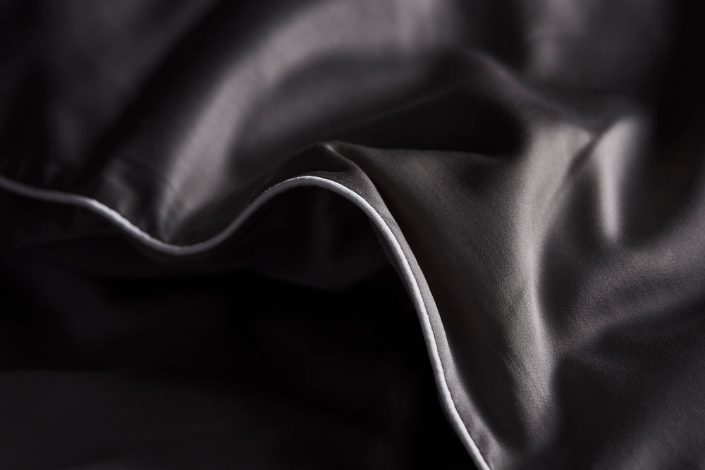 Bamboo lyocell duvet cover in Eldgos Aska grey, detail of the piped edge